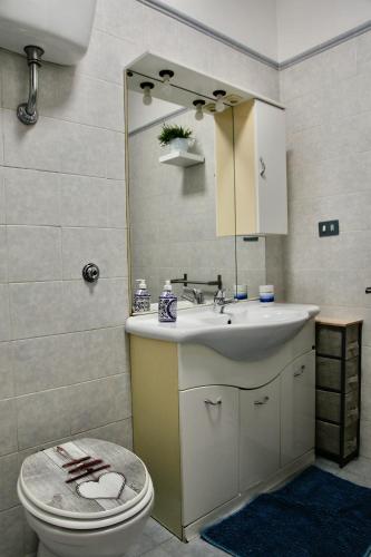 a bathroom with a sink and a toilet and a mirror at 4four Apartment 6-7 pax in Vitinia