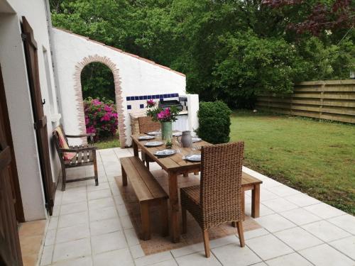 une table et des chaises en bois sur une terrasse dans l'établissement Maison landaise, à Josse
