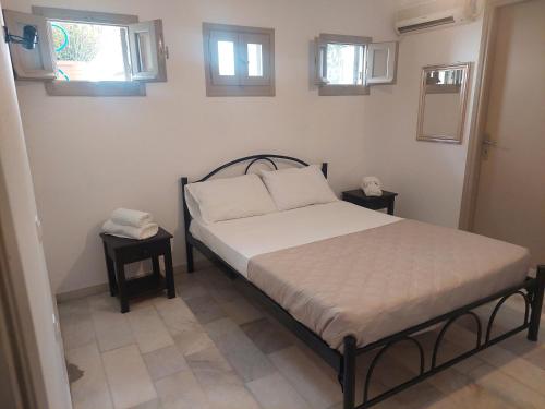 1 cama en una habitación con 2 mesas y 2 ventanas en stoudios en Naxos