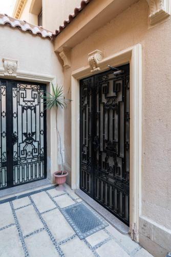 a building with black doors with a potted plant at Sleep Inn Apart-Hotel in Cairo