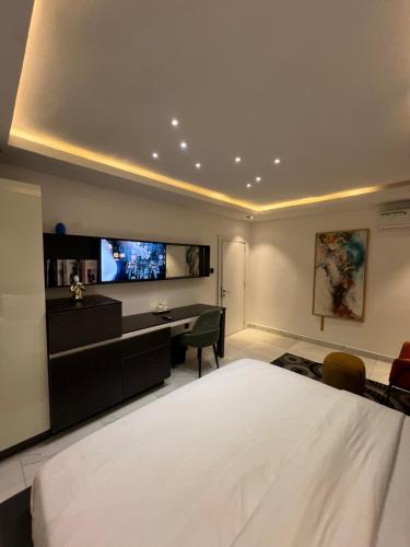 a bedroom with a bed and a desk and a television at Austra Villa Maitama Abuja in Abuja