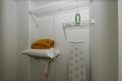 um quarto branco com uma prateleira e uma gravata em 2 bath Prkg+Gym+Sauna Perk Plaza +30 Day em Cleveland