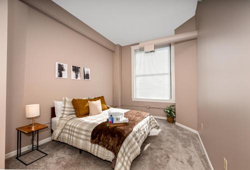 a bedroom with a bed and a window at 2 bath Prkg+Gym+Sauna Perk Plaza +30 Day in Cleveland