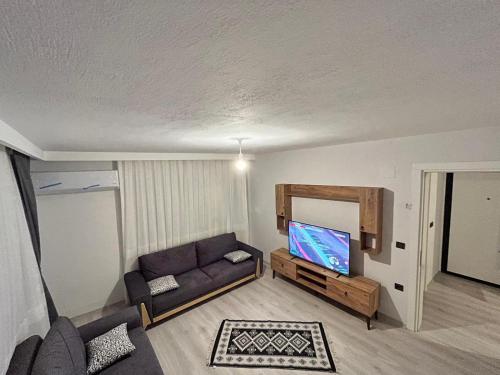 a living room with a couch and a flat screen tv at Kırevi-Airport in Ortaca