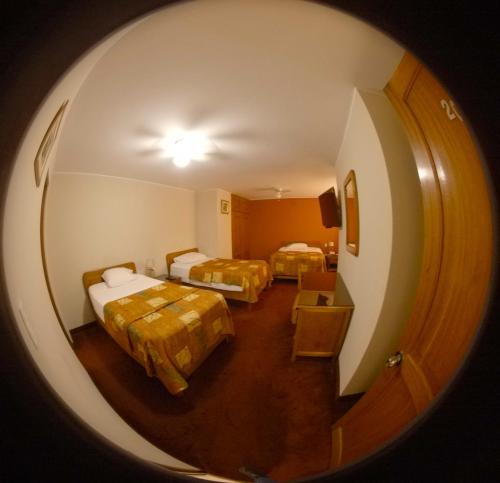 vista su una camera con due letti e un corridoio di Hotel La Molina a Lima