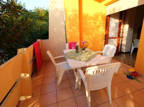 een witte tafel en stoelen op een balkon bij Relax in our serene apartment - Beahost Rentals in Bibione