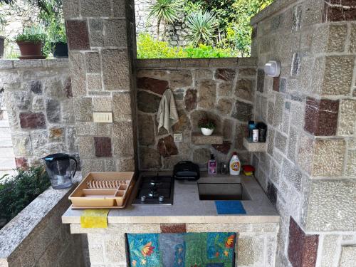uma cozinha exterior com um fogão e uma parede de pedra em Stone Villa em Bečići