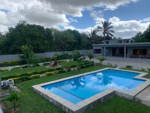 a swimming pool in the yard of a house at House of joy Bilene in Vila Praia Do Bilene