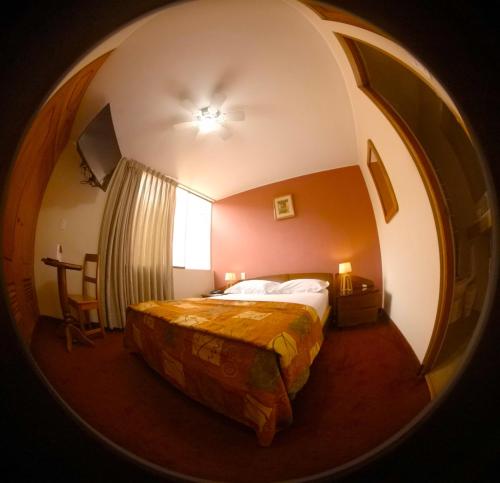 1 dormitorio con cama y espejo redondo en Hotel La Molina en Lima