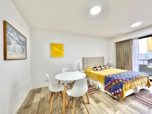 1 dormitorio con 1 cama, mesa y sillas en Cozy & sunny studio in Saavedra en Buenos Aires