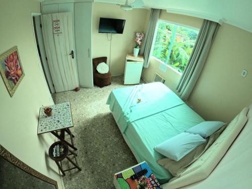 a small bedroom with a bed and a window at Hostel Paraíso in Arraial do Cabo
