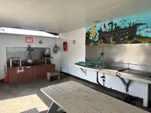 a room with a kitchen with a sink and a table at Captain John's Motel in Charleston