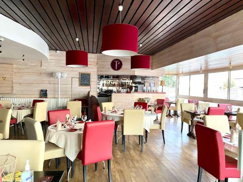 restauracja ze stołami, krzesłami i czerwonymi krzesłami w obiekcie Best Western de Diane - restaurant TAM's Cuisine Maison w mieście Nevers