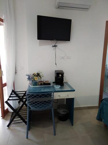 a blue desk with a television on a wall at Antares B&B in Cariati