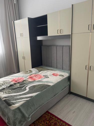 a bedroom with a bed with flowers on it at Guest house with mountain view in Pokrovka