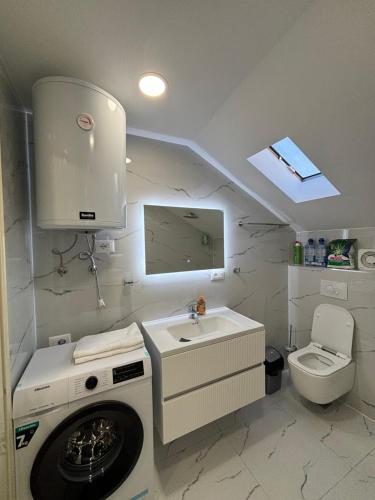 een badkamer met een wasmachine en een wastafel bij 2Bedroom Apartment,free parking 06 in Kamëz