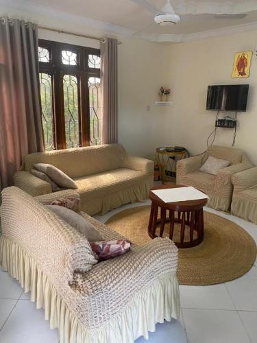 a living room with two couches and a table at Maasaifari peace 4 bed in Dar es Salaam
