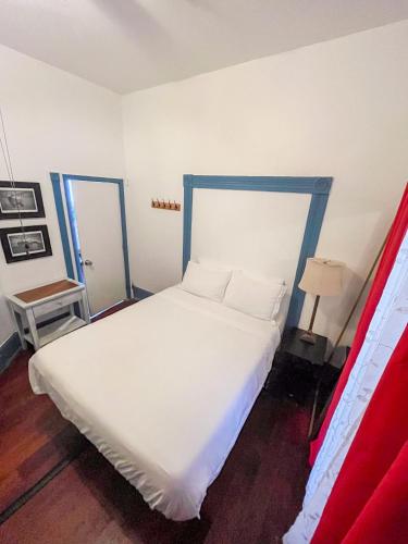 a bedroom with a white bed with a blue frame at ITH San Diego Adventure Hostel in San Diego
