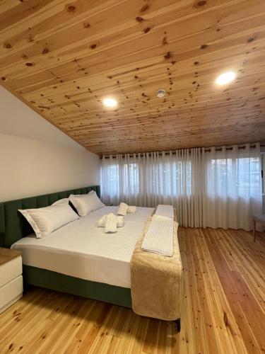 een groot bed in een kamer met een houten plafond bij 2Bedroom Apartment,free parking 06 in Kamëz