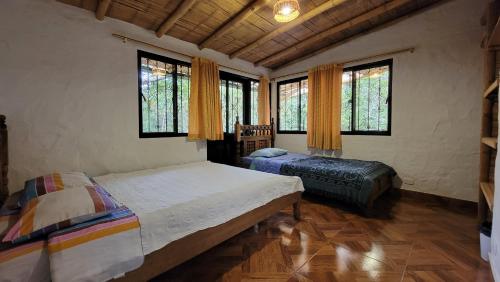 1 dormitorio con 1 cama, 1 silla y ventanas en Hotel Ecológico La Antigua, en San Agustín