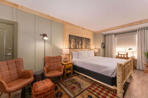 a bedroom with a large bed and two chairs at Prestige Harbourfront Resort, WorldHotels Luxury in Salmon Arm