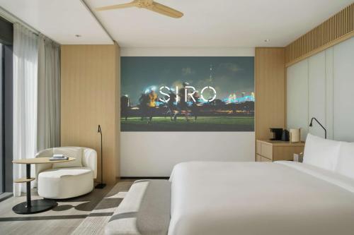 a hotel room with a bed and a sign that says stop at SIRO One Za'abeel in Dubai