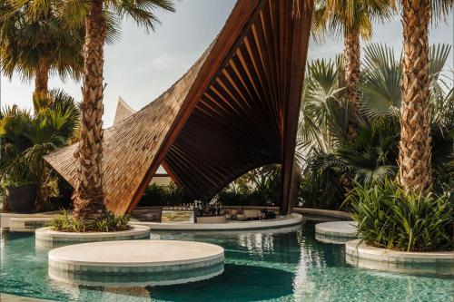 een resort met palmbomen en een zwembad bij SIRO One Za'abeel in Dubai