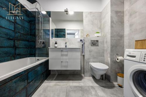 ein Badezimmer mit einem WC, einem Waschbecken und einer Waschmaschine in der Unterkunft ELEGANT Apartment Mechaniczna 5W in Głogów