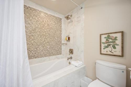 a white bathroom with a tub and a toilet at Hotel Bellwether on Bellingham Bay in Bellingham