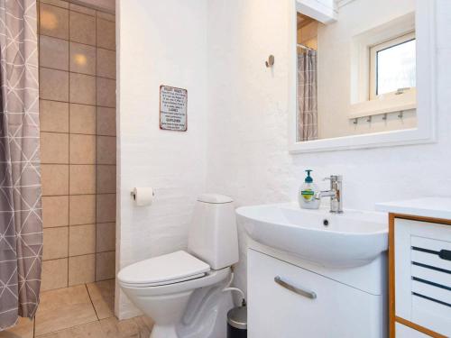 羅蒙柯克比的住宿－Holiday home Rømø XV，白色的浴室设有卫生间和水槽。