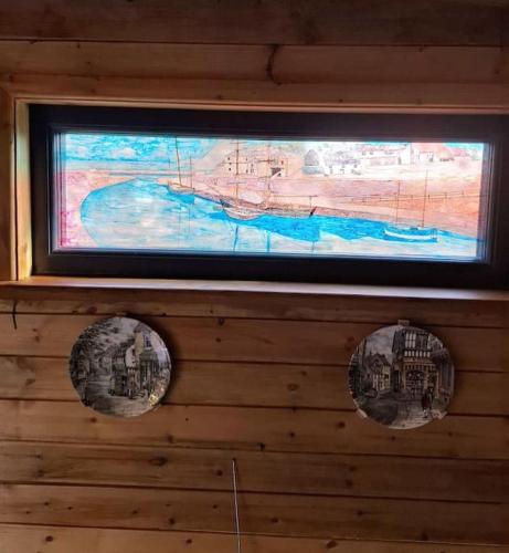 a painting hanging on a wall with two balls at Cosy Cornish Cabin in St Austell