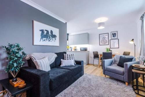 a living room with a blue couch and a kitchen at NEW! Stylish 1-Bed Flat in Crewe by 53 Degrees Property - Ideal for Business & Professionals - Sleeps 3! in Crewe