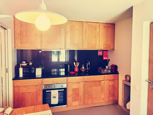 una cocina con armarios de madera y luz eólica en Casa Do Pio Soajo, en Arcos de Valdevez