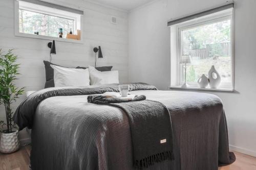 a bedroom with a bed with a blanket on it at Swedish Costal Forest Hideaway in Yngsjö