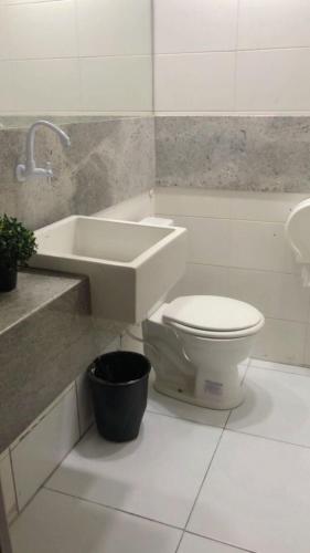 uma casa de banho com um WC branco e um lavatório. em Pousada Casa Mar Pajuçara em Maceió