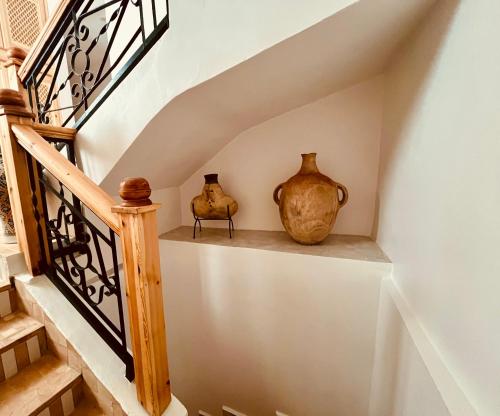 two vases sitting on a shelf under a staircase at RIAD OASIS D'ASILAH in Asilah