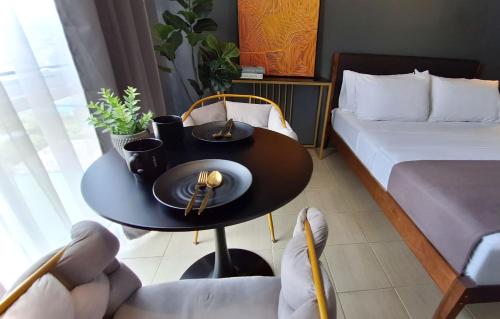 The French Apartment Pasig - Fast Wi-Fi and pool في مانيلا: غرفة بطاولة وسرير وطاولة وكراسي