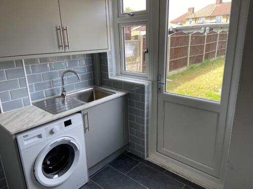 a kitchen with a washing machine and a sink at Peeams abode in Dagenham