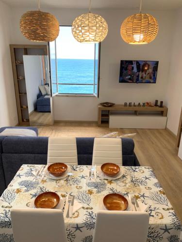 ein Wohnzimmer mit einem Tisch und Meerblick in der Unterkunft Affacciati al mare in Finale Ligure