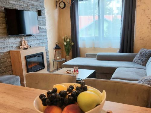 a living room with a bowl of fruit on a table at Happy Dreams Spa Zlatibor in Zlatibor