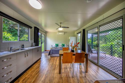 a kitchen and dining room with a table and chairs at Mena Creek Flower House in Mena Creek