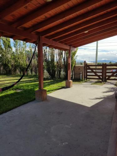 a covered patio with a fence and a gate at Azucena1001 in El Calafate
