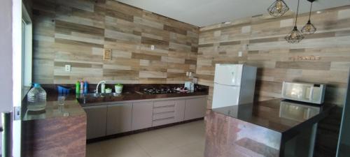 een keuken met een aanrecht en een koelkast bij Rancho Léo Artes in Três Marias