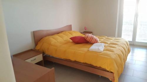 Affittacamere SantaMaria في Scordia: غرفة نوم بسرير اصفر مع وسادتين