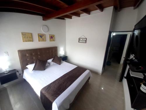 ein Schlafzimmer mit einem Bett und einem TV in der Unterkunft Hotel boutique San Pablo in Medellín