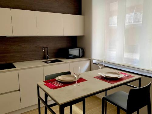 a small kitchen with a table with two wine glasses at Casa vacanze Mirage in Bergamo