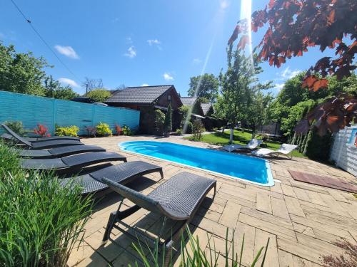 un patio con tumbonas y una piscina en Domki w sadzie Stegna en Stegna