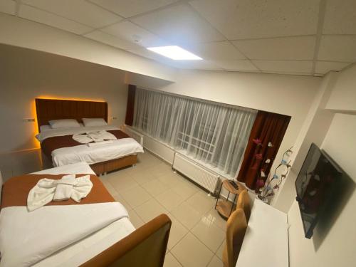 um quarto de hotel com duas camas e uma televisão de ecrã plano em Kadıköy Bull Hotel em Istambul