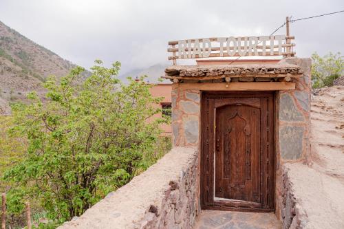 a small building with a wooden door on a hill at Riad Tourtit in Imlil