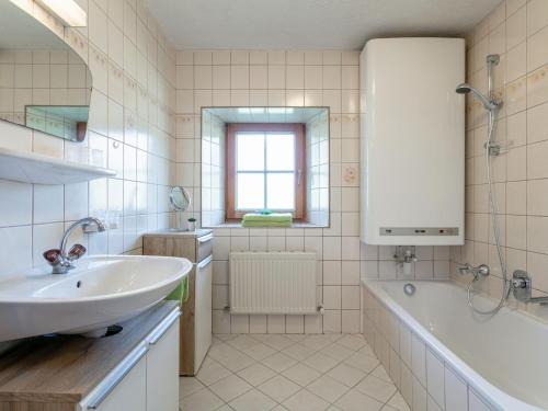 a white bathroom with a tub and a sink at Bauernhof Seppen in Reith im Alpbachtal